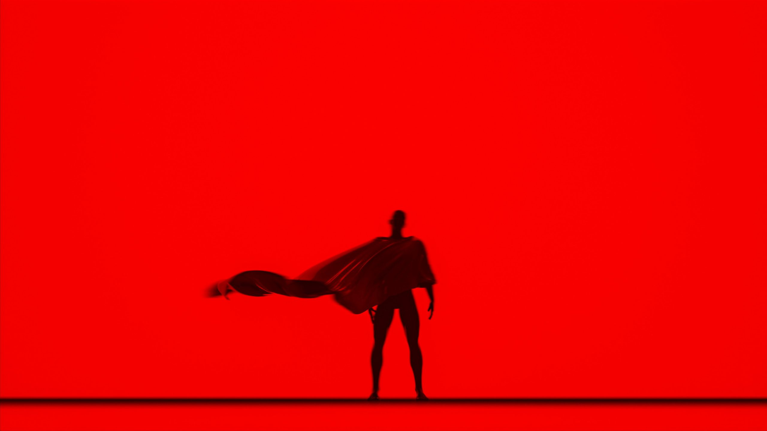 Caped person stands in silhouette.
